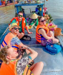 Travelers enjoying an authentic Mekong Delta floating market boat cruise during a day trip from Ho Chi Minh City.