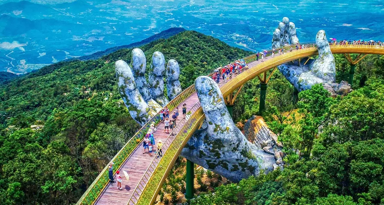 High-angle aerial view of the Golden Bridge (Cau Vang) held by giant hands at Sun World Ba Na Hills, Da Nang, Vietnam.