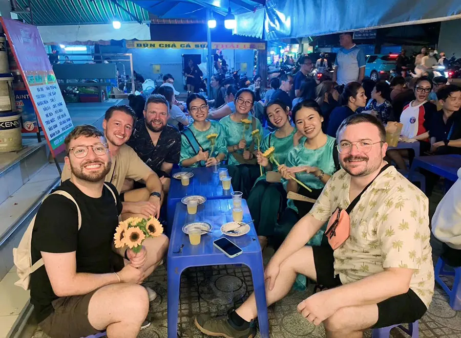 Guests tasting authentic Vietnamese street food during a guided Saigon walking food tour.