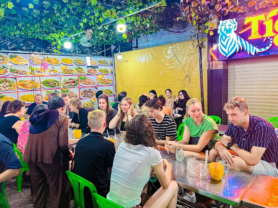 Saigon street food adventure with travelers joining a guided Saigon Food Tour.