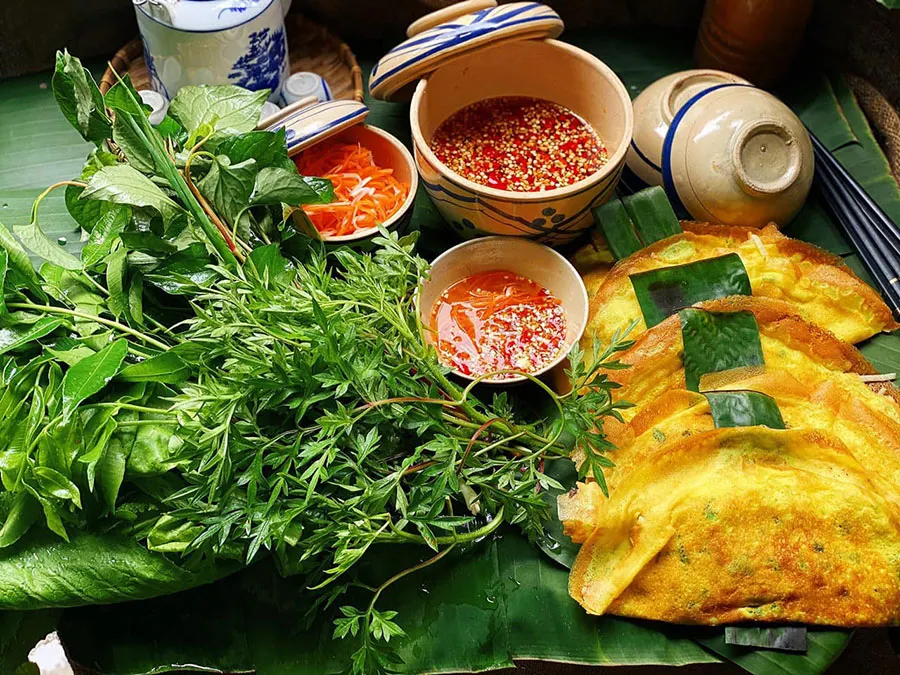 Traditional Banh Xeo with vegetables and dipping sauce in Vietnam