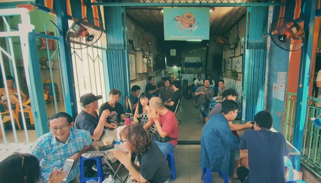 Local patrons enjoying traditional cloth-filter coffee at Cheo Leo Cafe, the oldest coffee shop in Ho Chi Minh City, during a private motorbike tour.