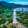 Aerial view of the Linh Ung Pagoda complex and the giant Lady Buddha statue on the lush Son Tra Peninsula overlooking Da Nang Bay.