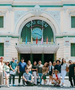 Tourists visiting Saigon Central Post Office on a street food and sightseeing scooter tour