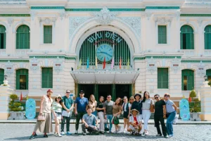 Tourists visiting Saigon Central Post Office on a street food and sightseeing scooter tour