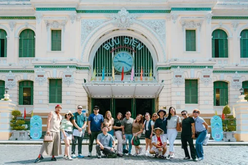 Tourists visiting Saigon Central Post Office on a street food and sightseeing scooter tour
