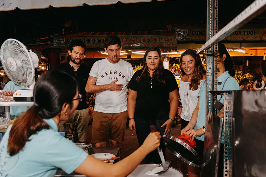 Travelers discovering Vietnamese street food with a local guide