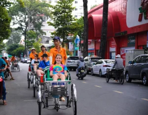 Cyclo Rickshaw Tour featuring international tourists exploring historic streets, local culture, traditional transportation, and authentic Vietnam travel experiences.