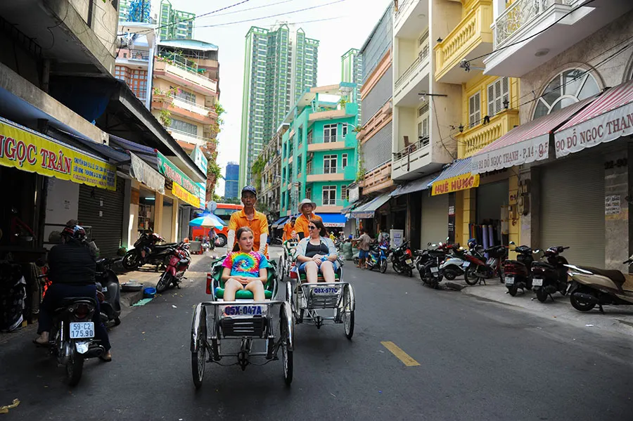 Best Cyclo Rickshaw Tour in Vietnam with happy travelers exploring iconic landmarks and authentic local street life.