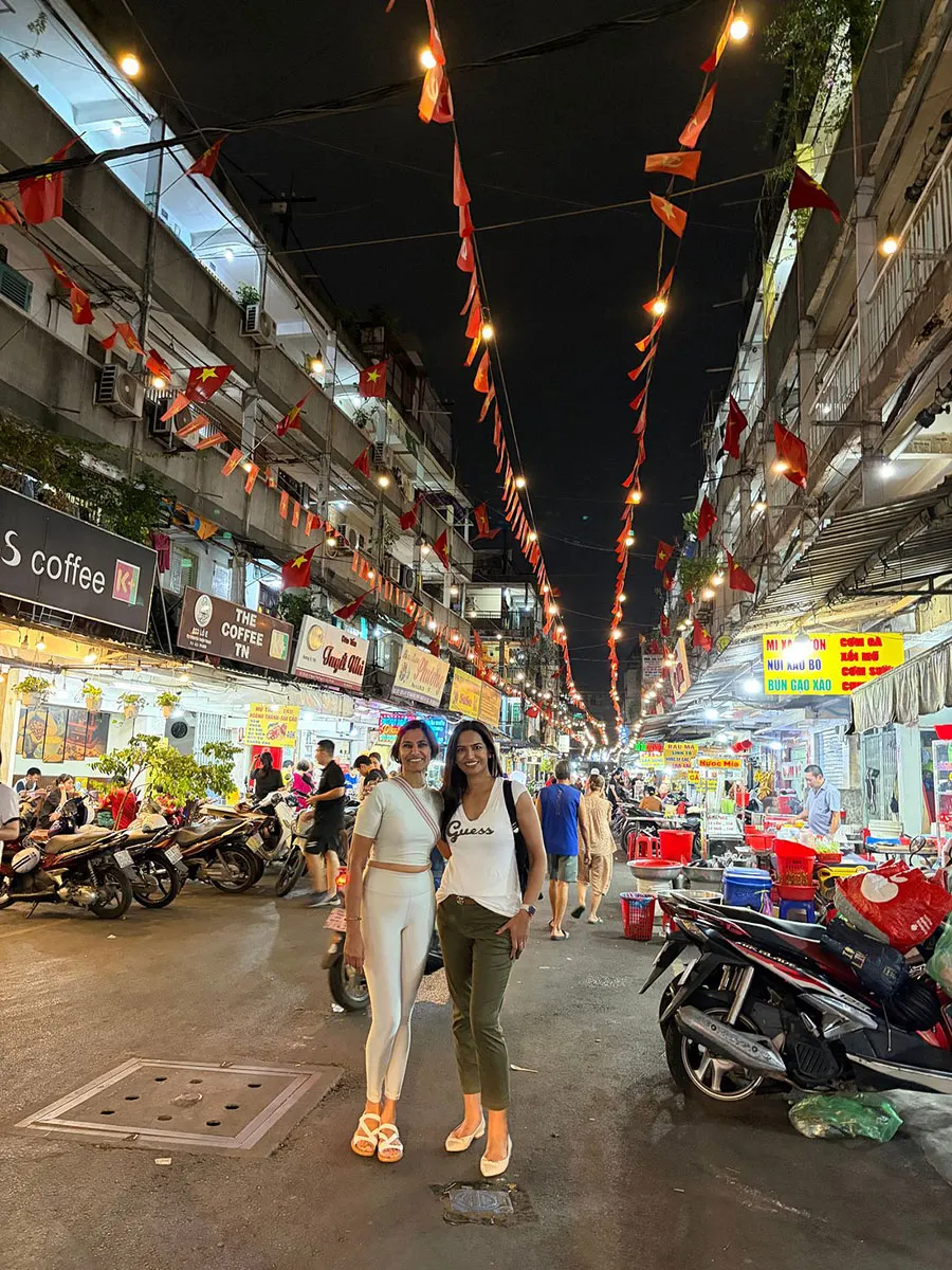 isitors enjoying a night scooter adventure through the lively streets of Saigon.