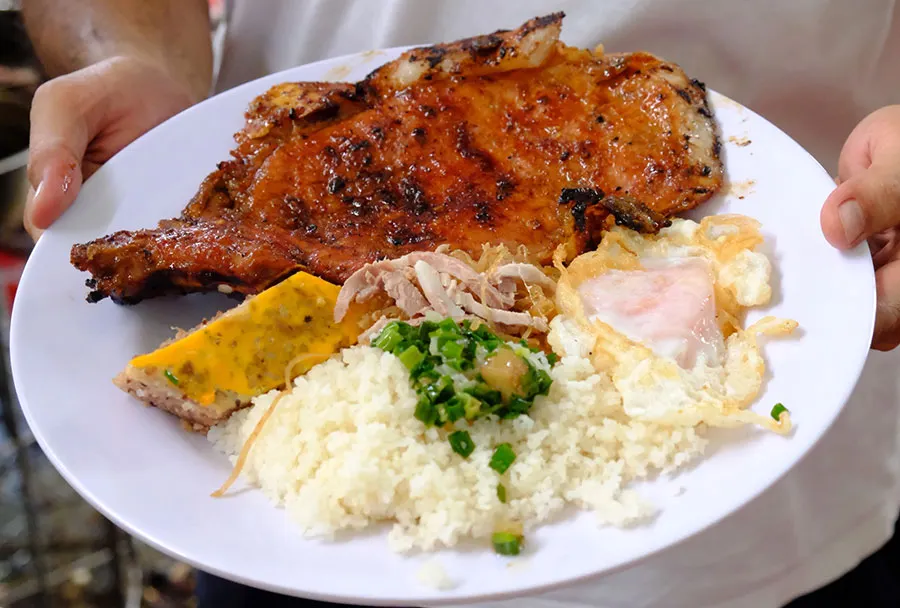 Travelers enjoying Com Tam Ba Ghien, the only Michelin Bib Gourmand broken rice restaurant in Vietnam