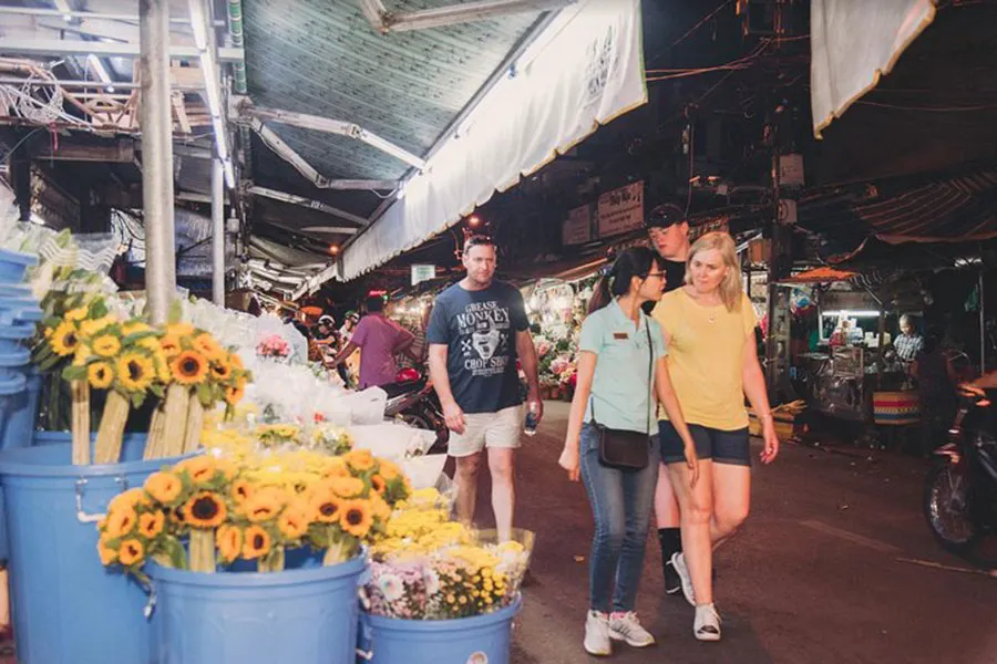 7 Best Neighborhoods to Explore on Foot in Ho Chi Minh City 8 Local guide walking with tourists through a traditional Saigon flower market