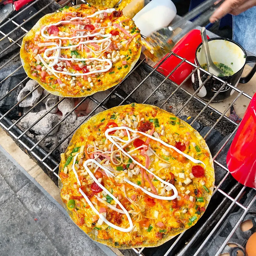 Best Street Food in District 10, Ho Chi Minh City 3 Authentic Saigon bánh tráng nướng topped with egg, scallions, sausage and creamy sauce.
