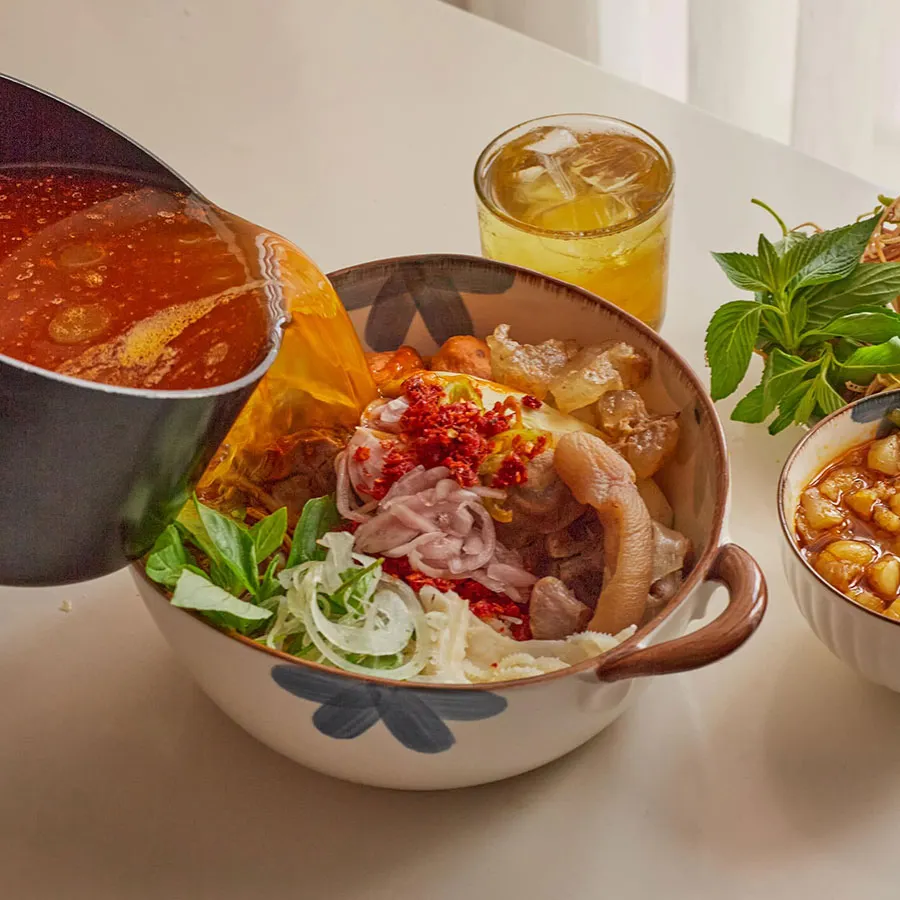 Is Street Food in Ho Chi Minh City Spicy? 5 Authentic bún bò Huế featuring a robust lemongrass broth, tender beef and chili oil for extra heat