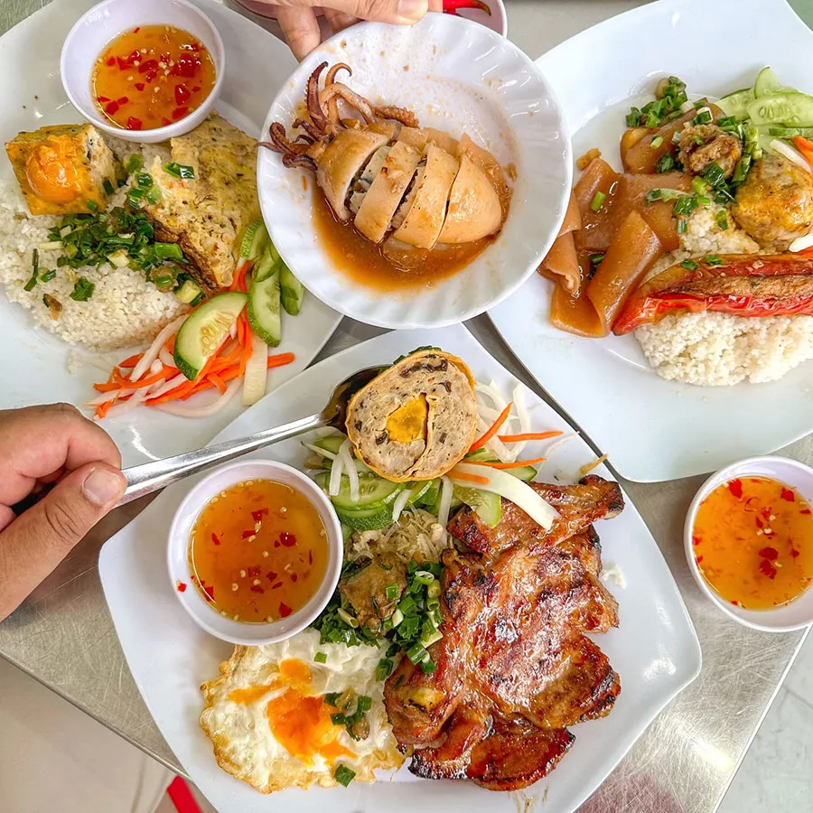 Is Street Food in Ho Chi Minh City Spicy? 4 Saigon broken rice with smoky grilled pork, scallion oil, pickled vegetables and a side of chili fish sauce