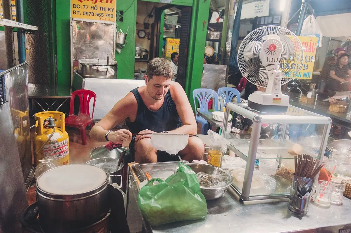 Saigon Sightseeing and Street Food in One Evening: A 4-Hour Itinerary 4 First-time visitor exploring how local street food is prepared in Ho Chi Minh City.