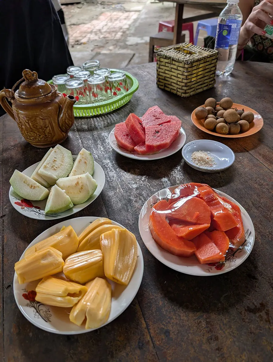 What Is the Mekong Delta Famous For? 10 Experiences You Shouldn’t Miss 3 Tourists enjoying seasonal fruit at a Mekong Delta garden
