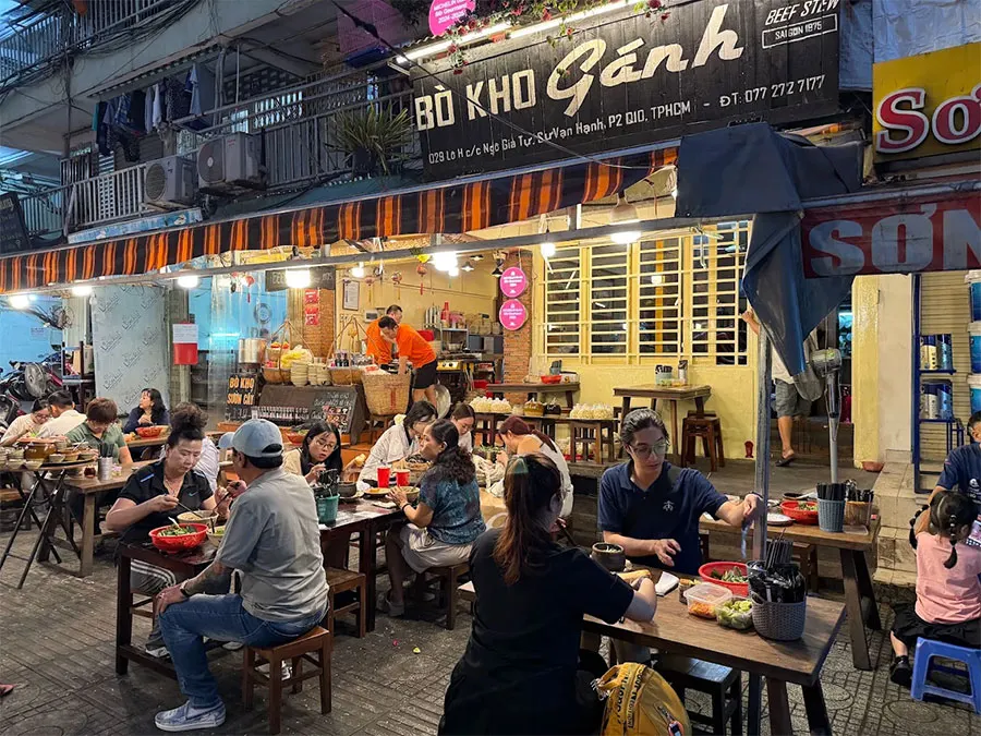 What Time Do Locals Eat in Ho Chi Minh City? A Guide to Saigon Meal Times 5 Local travelers enjoying Saigon street food during evening dining hours in Ho Chi Minh City