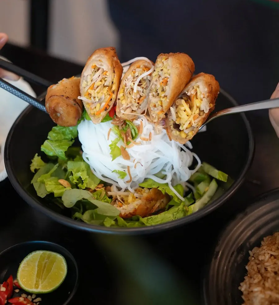 Vegetarian Street Food in Ho Chi Minh City: What to Eat and Where to Find It 5 Traveler enjoying bún thịt nướng chay during a Saigon vegetarian food experience