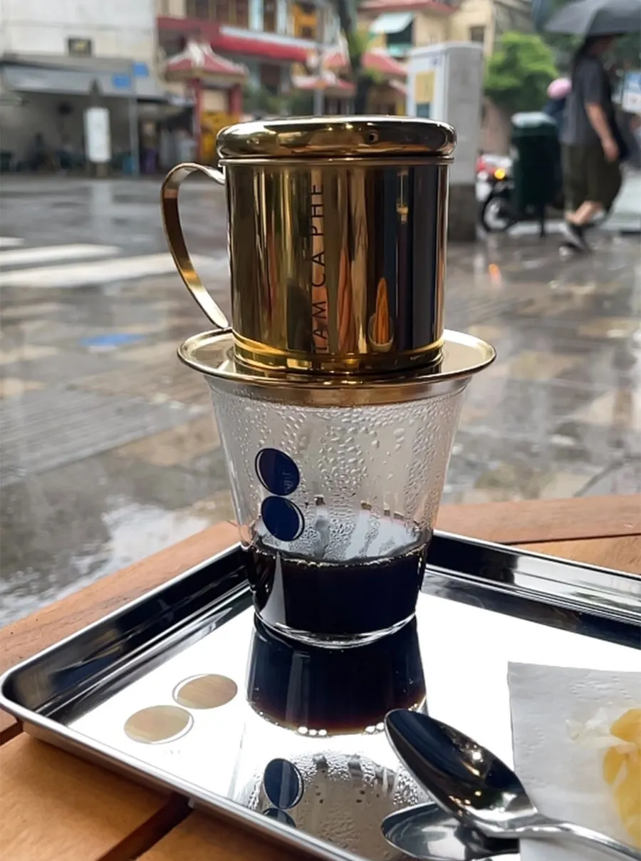 Sidewalk Coffee in Ho Chi Minh City: A Local Guide to Saigon’s Street Café Culture 4 A glass of Vietnamese black coffee brewed with a traditional phin filter at a sidewalk café.