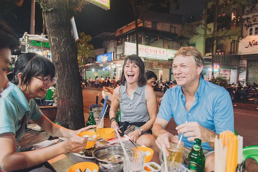 How to Eat Street Food Safely in Ho Chi Minh City: A Practical Traveler’s Guide 1 International visitors enjoy delicious street food with clean and careful preparation