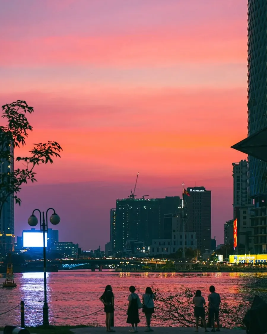 Saigon River Sunset: Best Places and Ways to Experience It 2 Travelers watching a colorful Saigon River sunset from a public riverside park