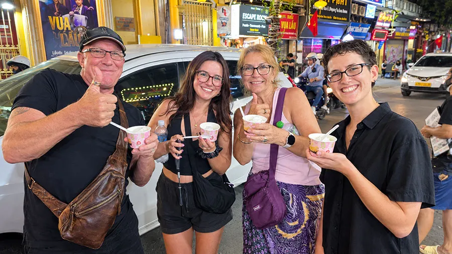 Where to Stay in Hanoi for Food Lovers: 5 Best Areas for Local Eating 5 Travelers explore Hanoi at night, enjoying city lights, busy streets and the lively local atmosphere
