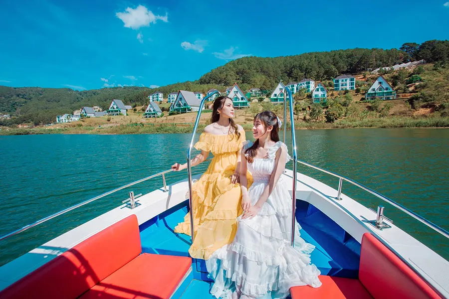 Dalat Wonderland: Is It Worth Visiting in 2026? 6 Tourists enjoying a scenic boat ride across Tuyen Lam Lake surrounded by pine-covered hills in Dalat