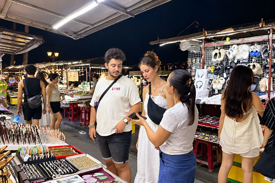Hoi An Night Market Food Guide: What to Try Beyond the Souvenir Stalls 1 Visitors browsing souvenir stalls at Hoi An night market